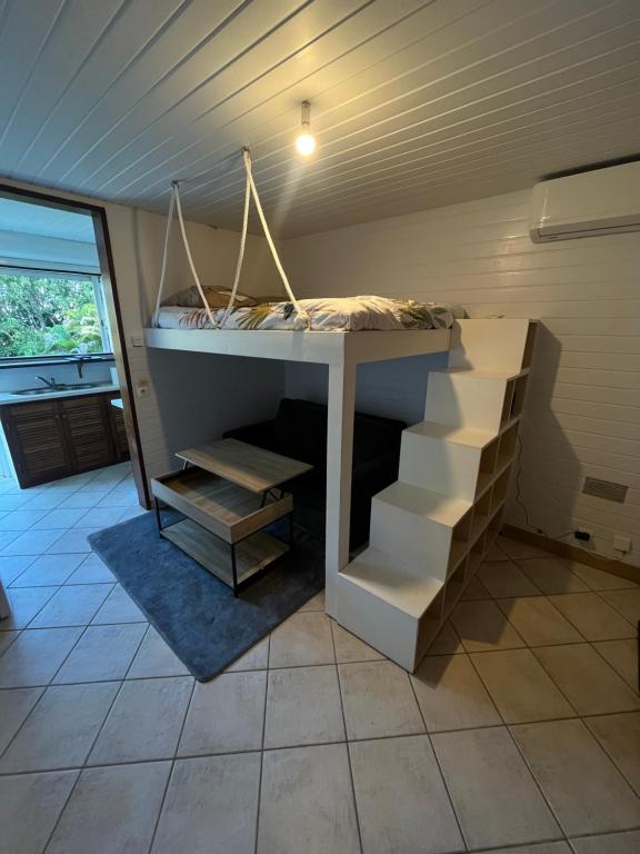 a bed in the corner of a room with stairs at Peace's House, Studio moderne, Bas-du-Fort, Plage à pied, Parking privé in Le Gosier