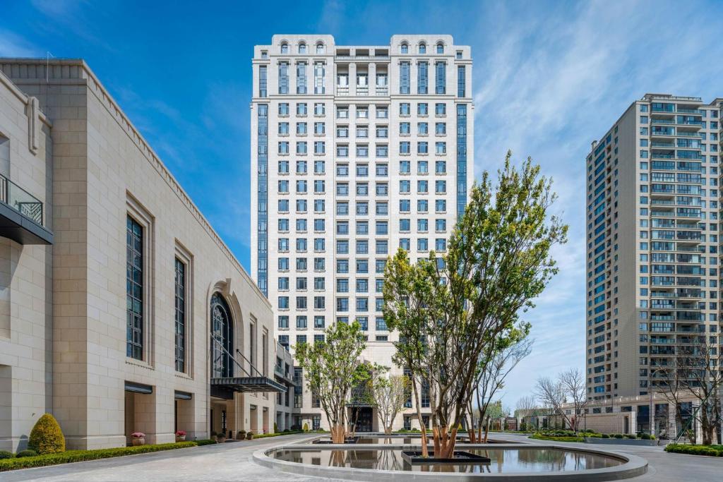 a tall white building with a tree in front of it at Four Points by Sheraton Qingtian in Qingtian