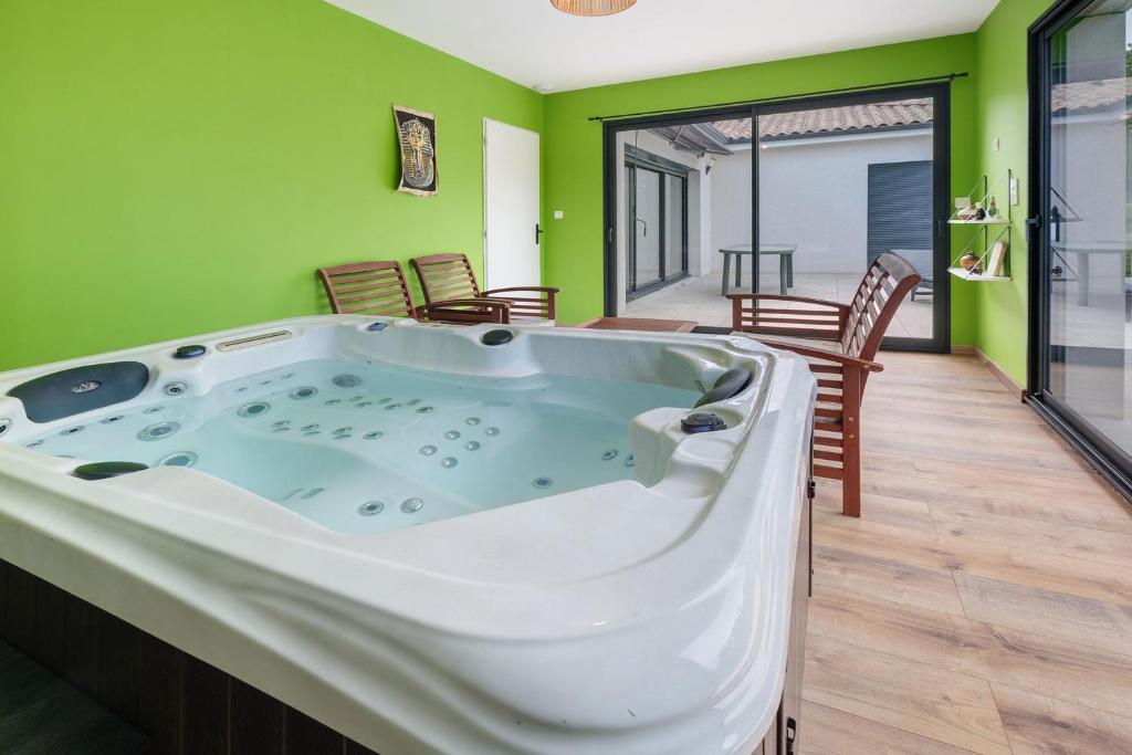 a jacuzzi tub in a room with green walls at Maison Peyrelade in Coulounieix-Chamiers