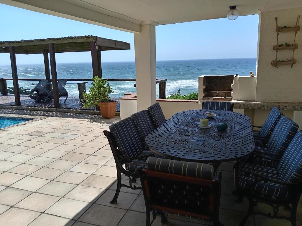 a table and chairs on a patio with a view of the ocean at Galene Guest House in Port Shepstone