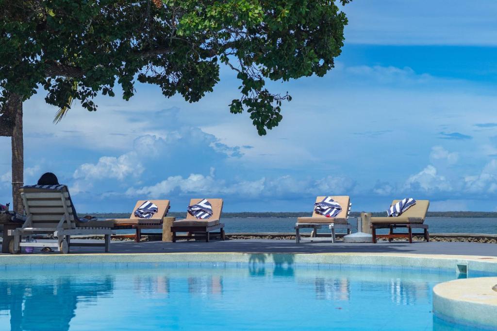 a group of chairs sitting next to a swimming pool at Mwazaro Beach Lodge in Shimoni