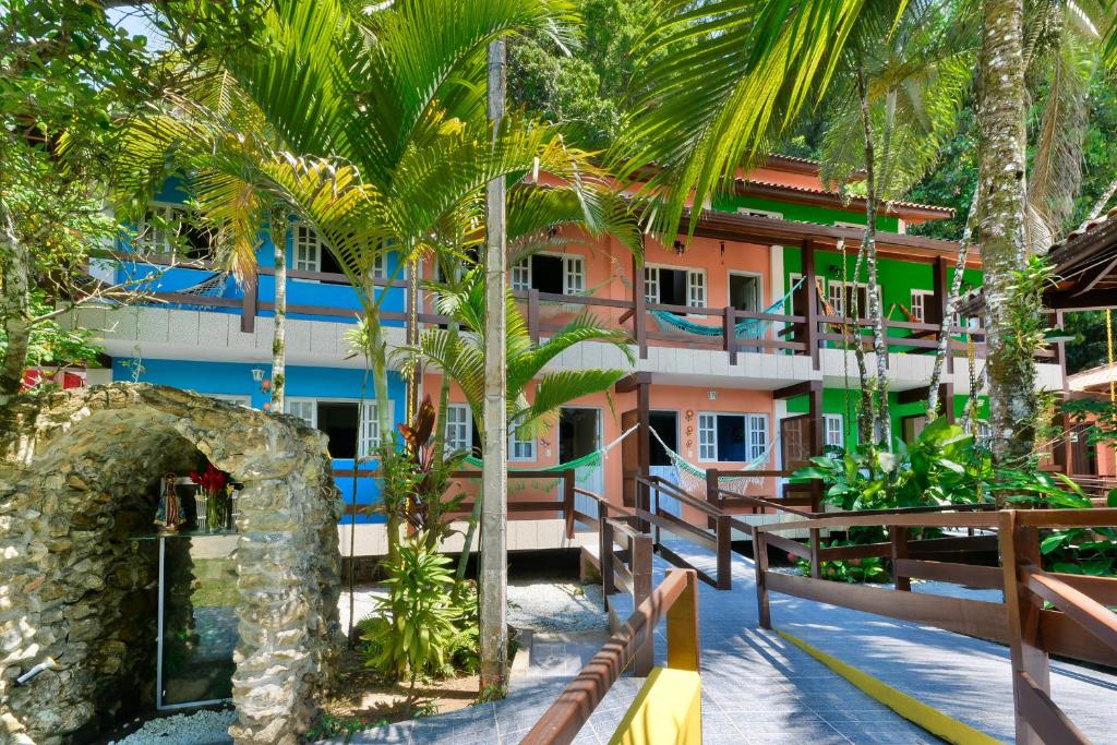 ein Resort mit Palmen vor einem Gebäude in der Unterkunft Pérola da Mata in Boicucanga