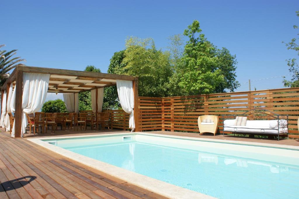 une piscine avec une clôture en bois et une terrasse en bois dans l'établissement Hotel & Ristorante degli Angeli, à Magliano Sabina