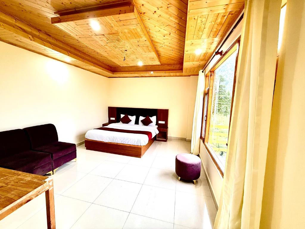 a bedroom with a bed and a wooden ceiling at The Cow Boy Manali in Manāli