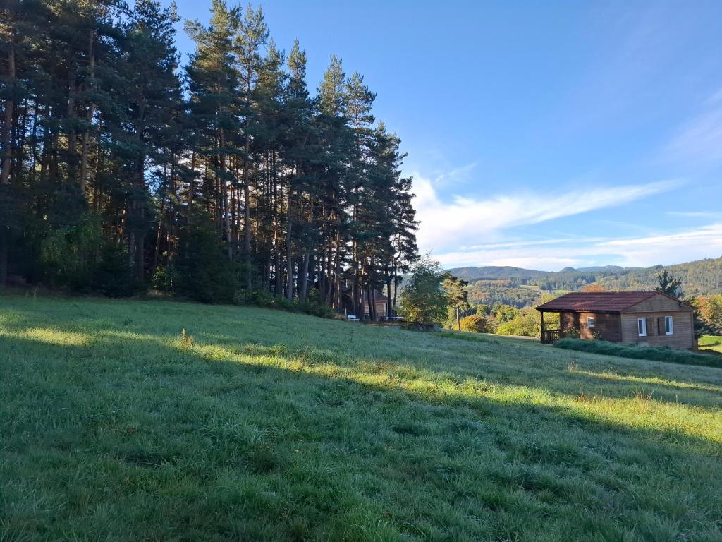 a field with a gazebo in the distance at Chalets au bord du lac de Lavalette in Lapte