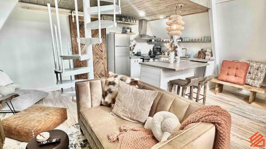 a living room with a couch and a kitchen at Serene Mountain Waterfront A-Frame Cabin in Robbinsville