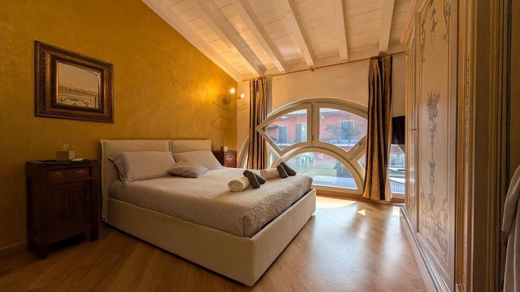 a bedroom with a bed and a large window at La Corte Di Dafne in Bergamo