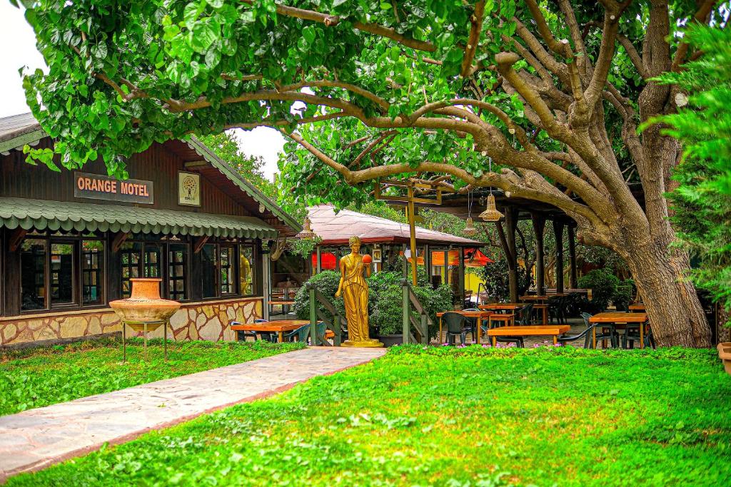a park with tables and chairs in front of a building at Çıralı Orange Motel in Cıralı