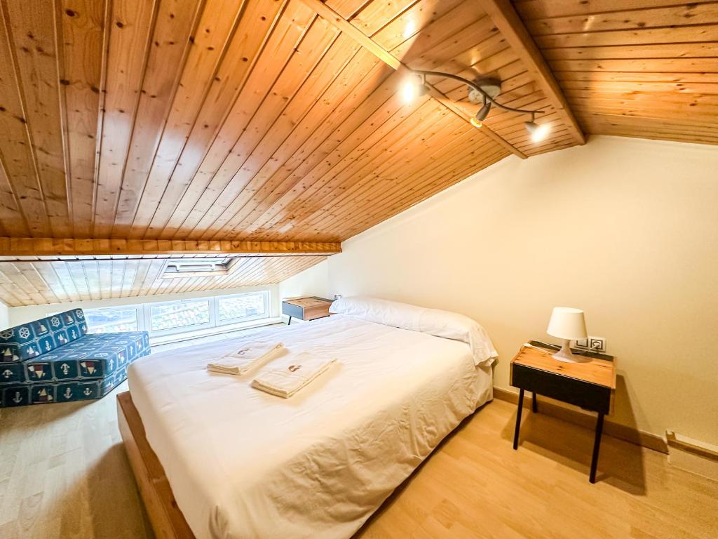 a bedroom with a large bed with a wooden ceiling at Casa das Faluchas by ALÔGA in Finisterre