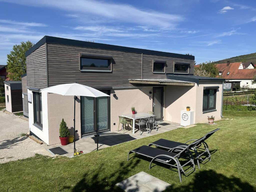 a small house with a table and chairs in the yard at Tinyhaus Ferien in Eggolsheim