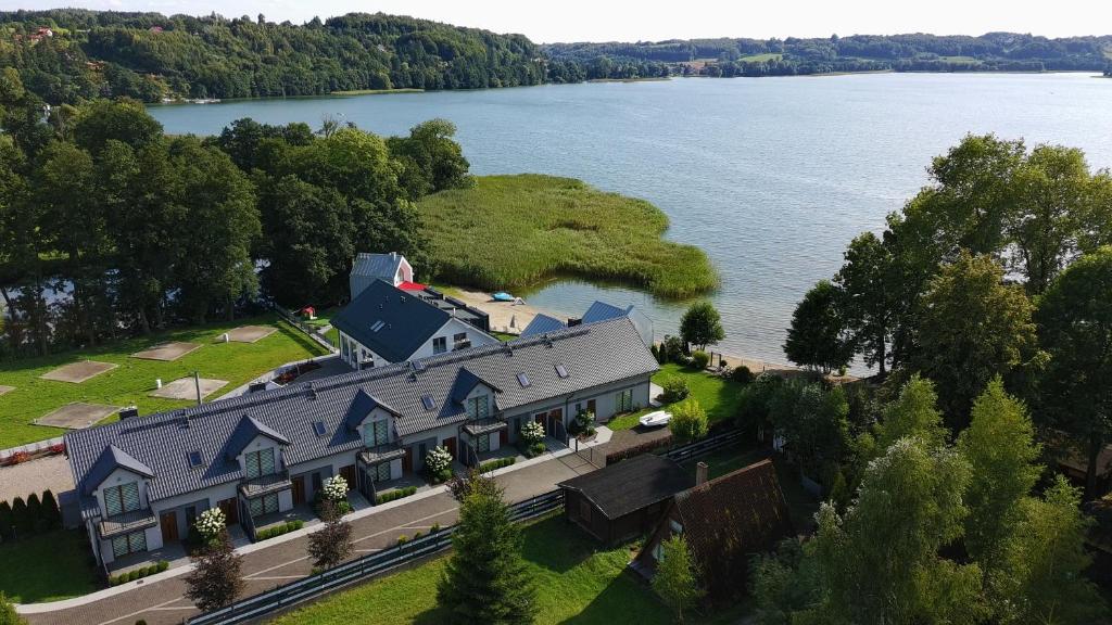 an aerial view of a large house next to a lake at Domki i Apartamenty WiR na Kaszubach in Chmielno