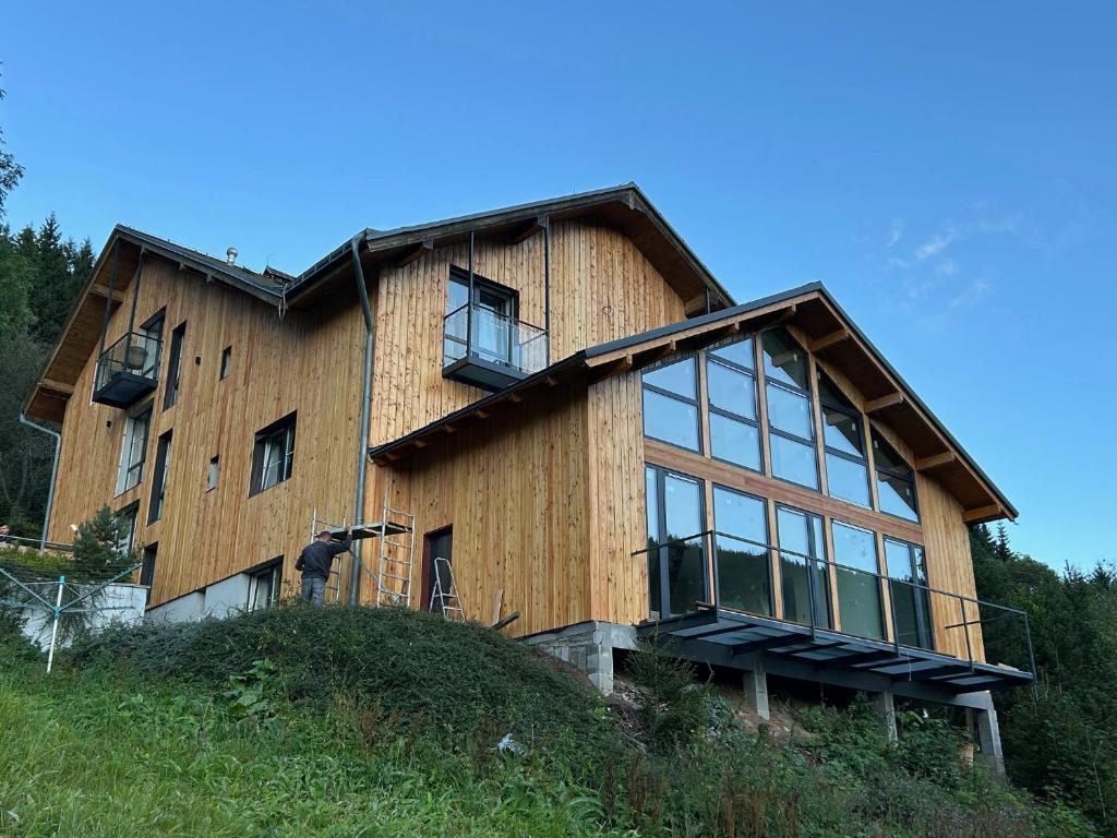 a house on top of a hill at Apartmány Gryf Harrachov u sjezdovky in Harrachov