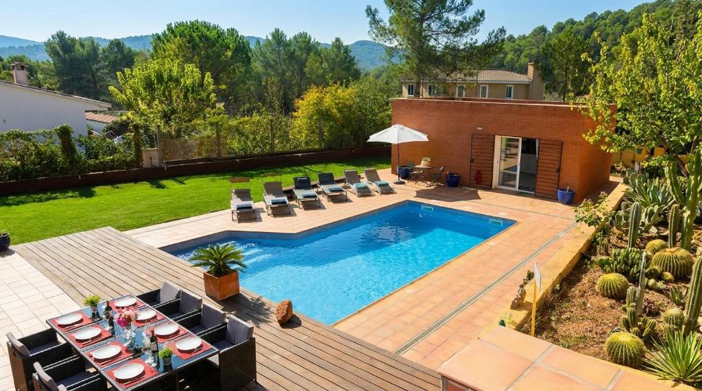 a swimming pool in a backyard with chairs and a table at Villa Sitges Maria Sunny Oriented SW AC Confortable High Quality 5 star guest coments in Olivella
