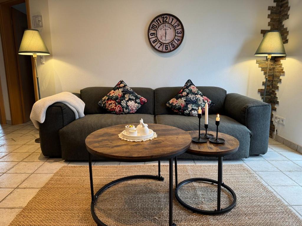a living room with a couch and two tables at Domblick und Eifelwind - Wohlfühlen und Erholen in Dahlem