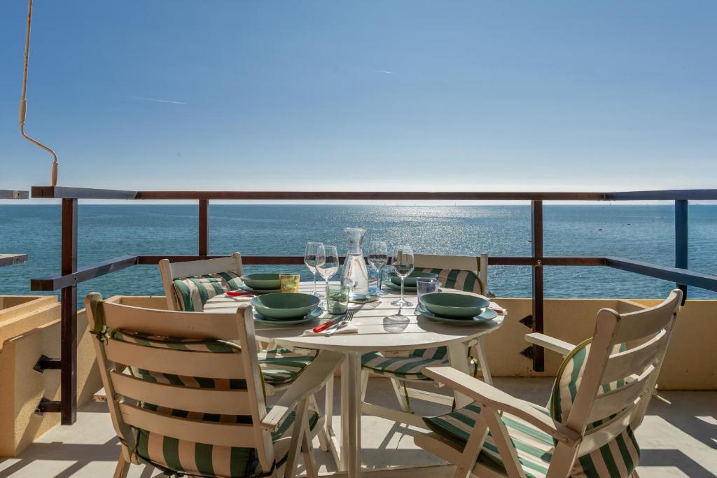 a table on a balcony with a view of the ocean at Fronte mare con parcheggio! in Grado