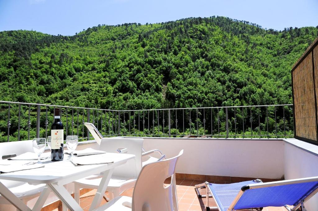 a white table and chairs on a balcony with a mountain at Panoramic Apartment with Balcony and Terrace in Pigna