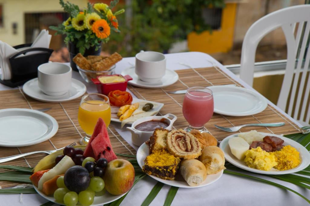 a table with plates of breakfast food on it at Pousada Maragolfinho in Maragogi