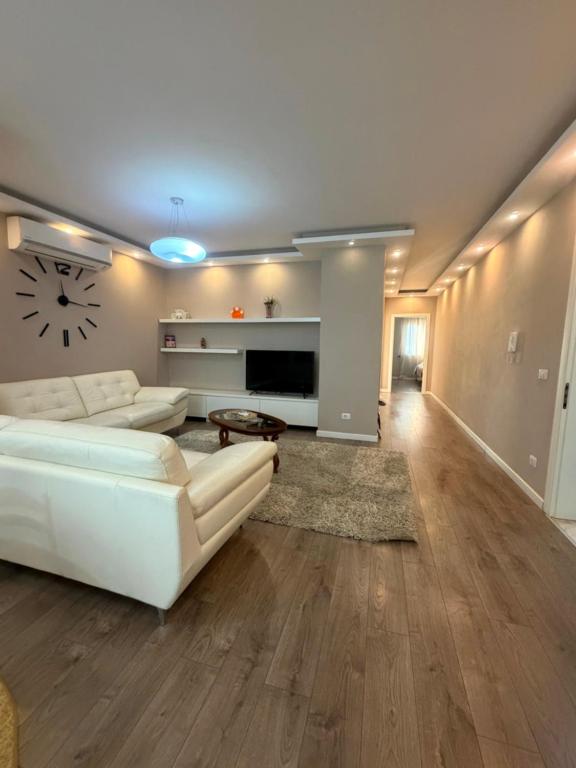 a living room with a white couch and a table at Valentina Cozy 2-Bedroom House in Lushnjë