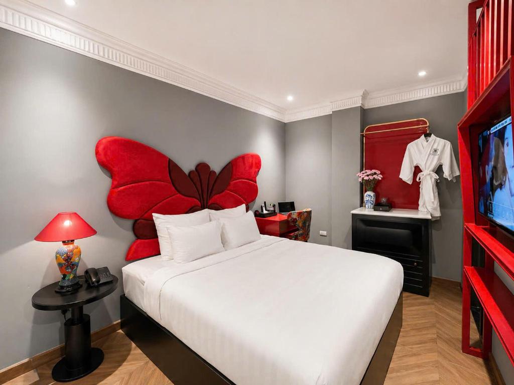 a bedroom with a large bed with a red flower headboard at Hanora Boutique Hotel in Hanoi
