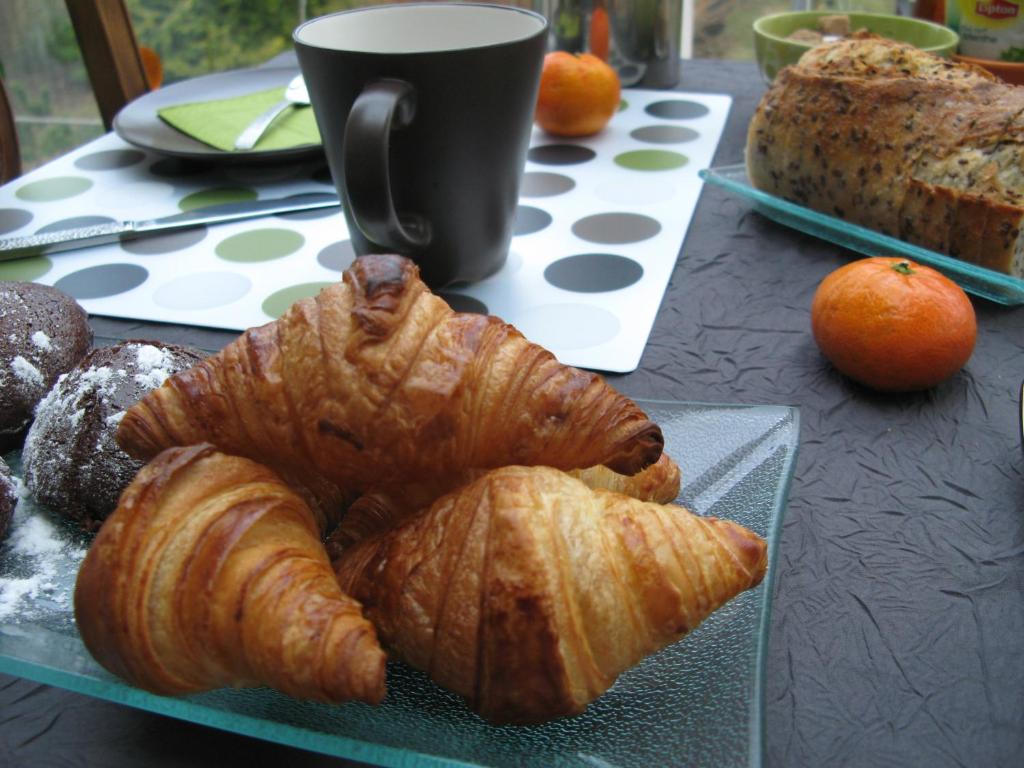 a table with a plate of croissants and a cup of coffee at Les Chambres de l'Ile in Metz