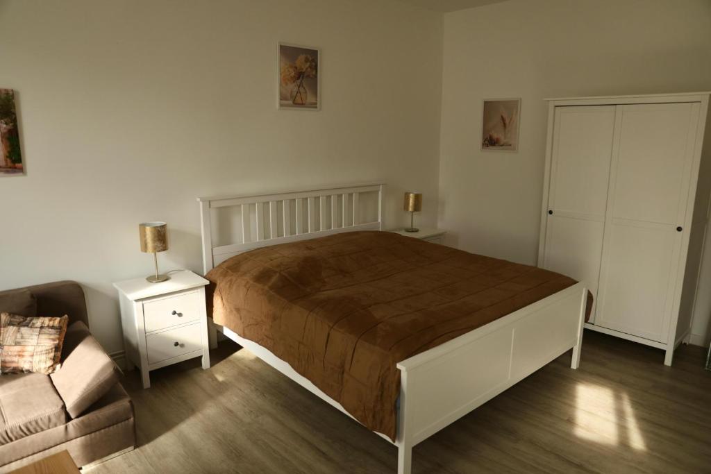 a bedroom with a large bed and a couch at Olive Residence Lübeck in Lübeck