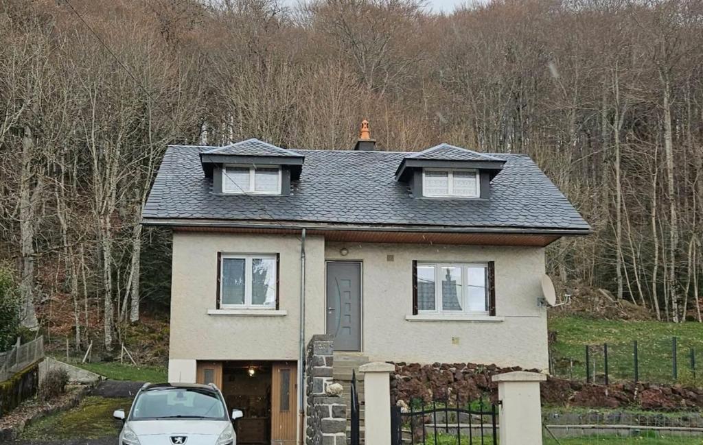 a house with a car parked in front of it at Maison de campagne in Picherande