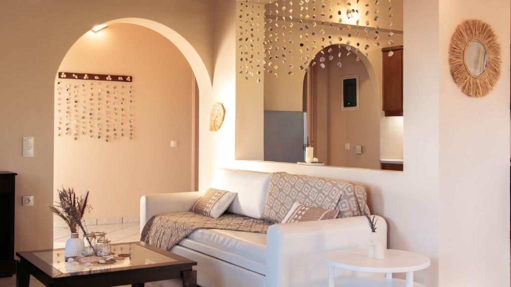 a living room with a couch and a mirror at Ocean Breeze Apartment - Panoramic Sea View & Olive Grove - 100m to Beach in Kypseli