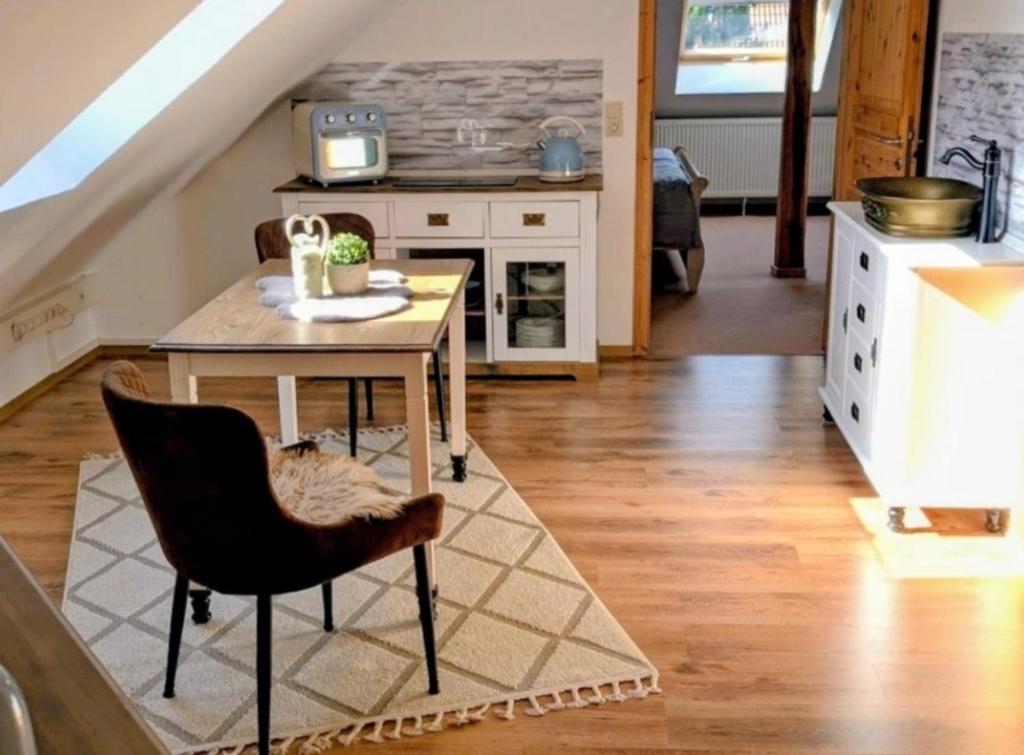 a kitchen with a table and a chair in a room at Nicht Daheim und doch Zuhaus in Heiligenhafen