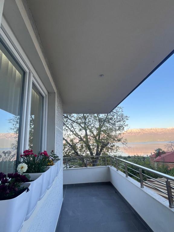 a balcony with flowers and a view of the water at Golden Stay in Pogradec
