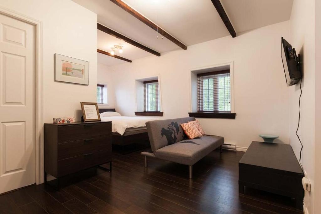 a bedroom with a bed and a couch and a chair at Comfort & Getaway in Old Levis - Studio Urbain in Lévis