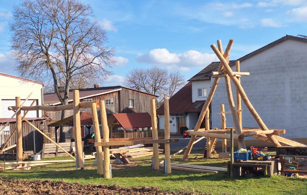 a group of wooden playground equipment in a yard at Ferienhof Mültner in Nordheim vor der Rhön