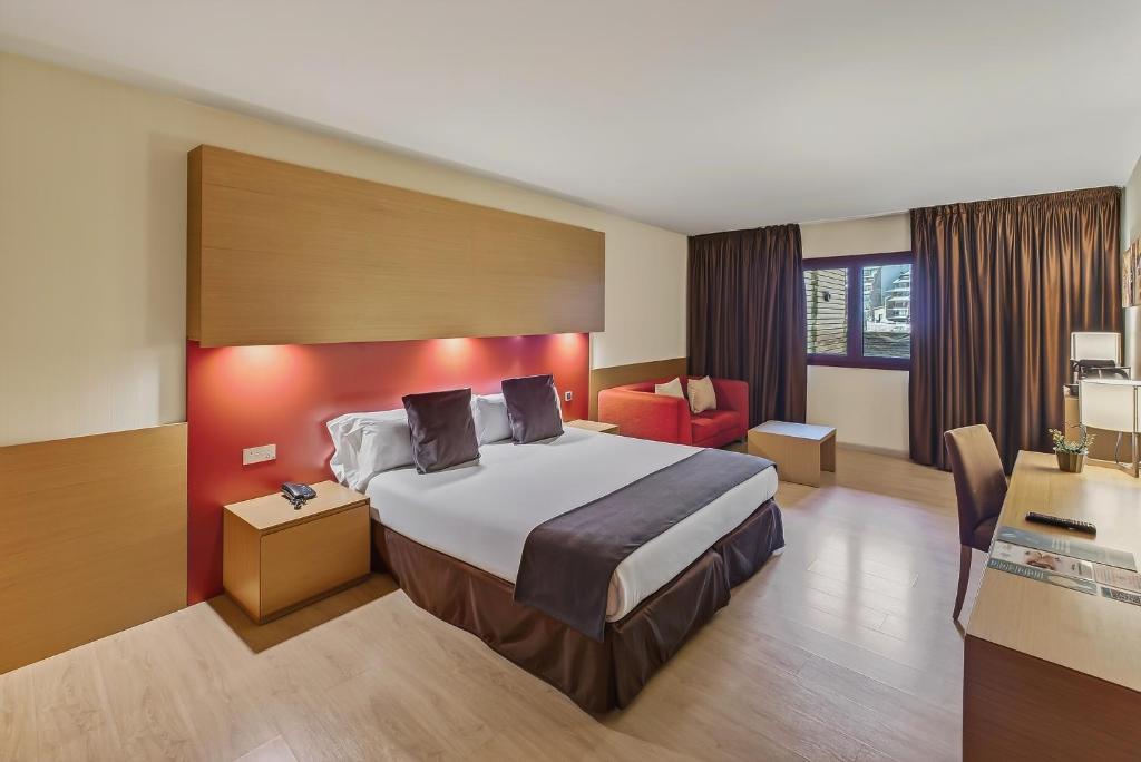 a hotel room with a large bed and a chair at Wuau! Hotel Galanthus & Spa in Soldeu
