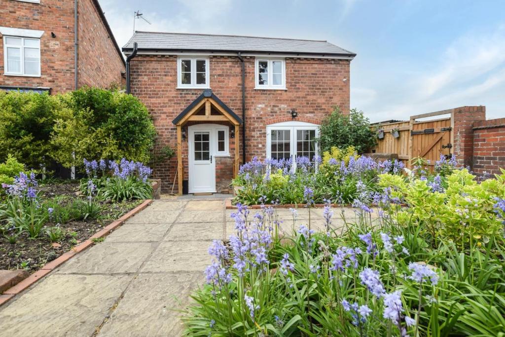 a brick house with a garden with purple flowers at 2 Bed in Bewdley oc-n31968 in Bewdley