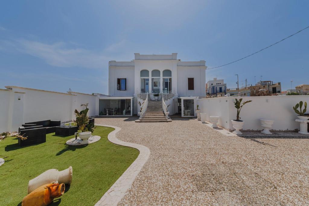 a white house with a grass yard in front of it at Ventidue Venti in Bari