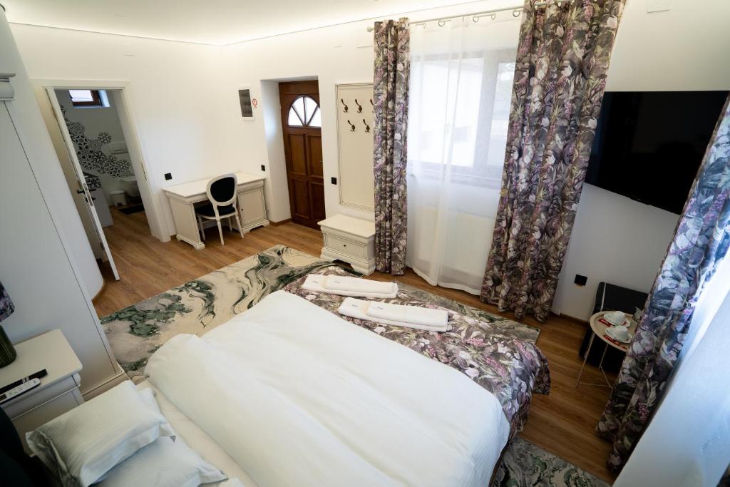 a living room with a bed and a tv at Serafim's Suites Airport in Iaşi
