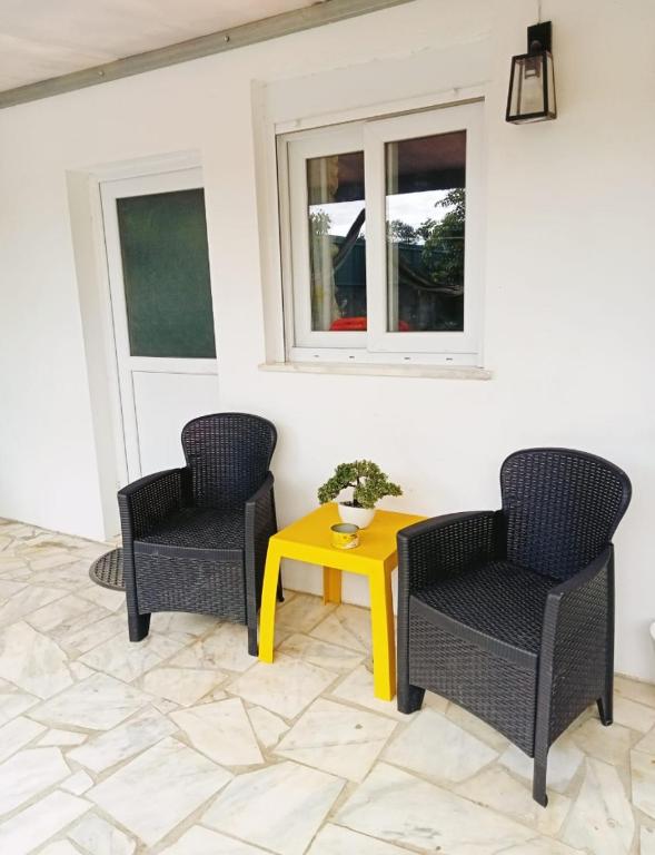 two chairs and a yellow table in a room at Estúdio ensolarado in Fernao Ferro