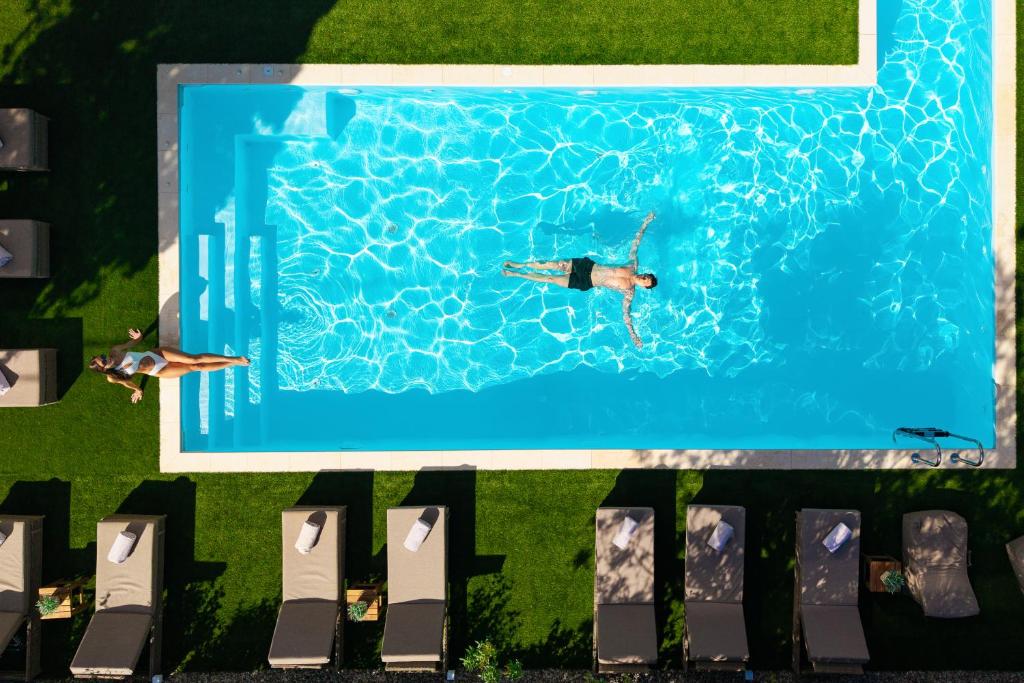 two people swimming in a swimming pool at Athenian Riviera Hotel& Suites in Athens