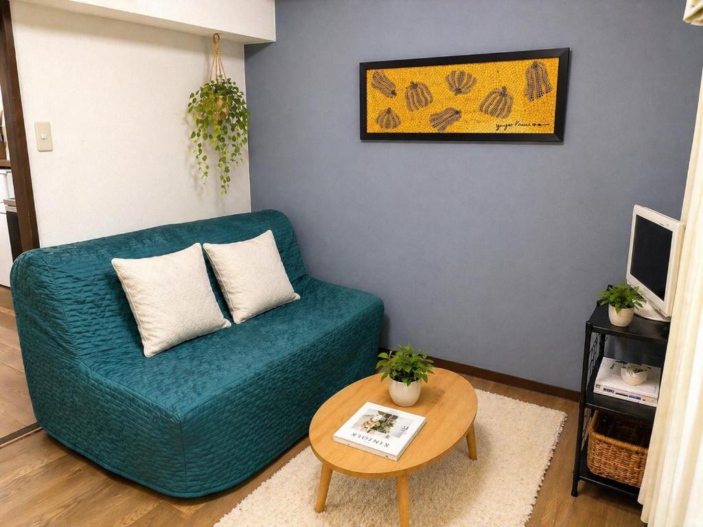 a living room with a blue couch and a table at 板橋 RCアネックス Rc302 in Tokyo
