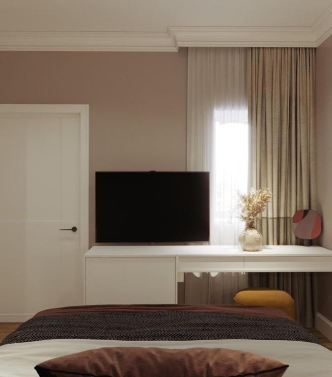 a bedroom with a flat screen tv and a bed at Aureline Hill in Baku