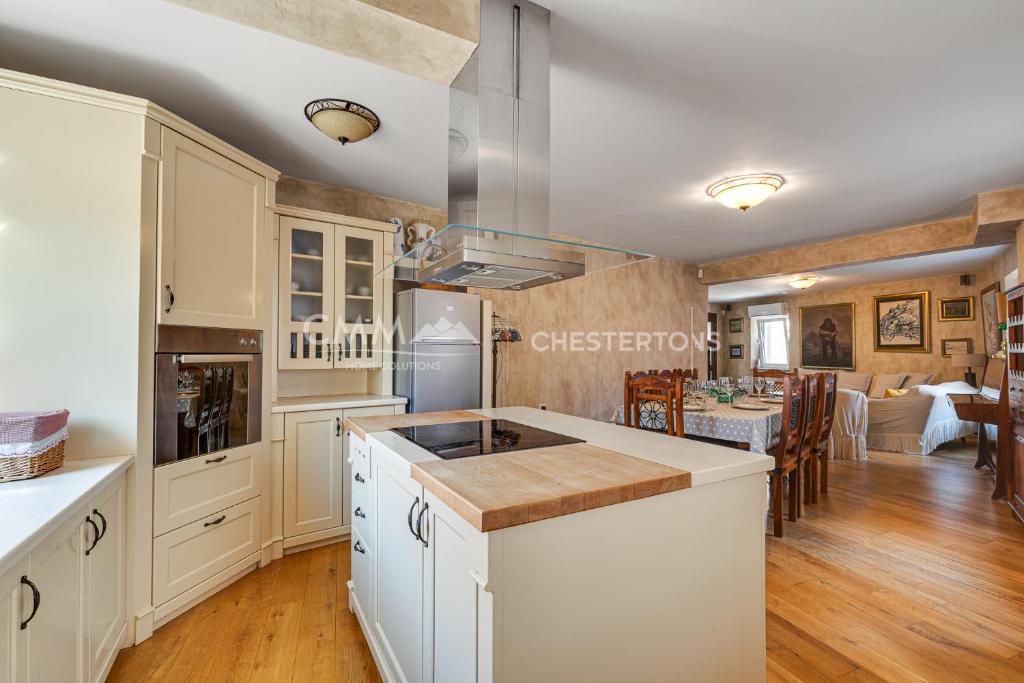 a kitchen with white cabinets and a dining room at Budva Old Town 3 bedroom Condo in Budva