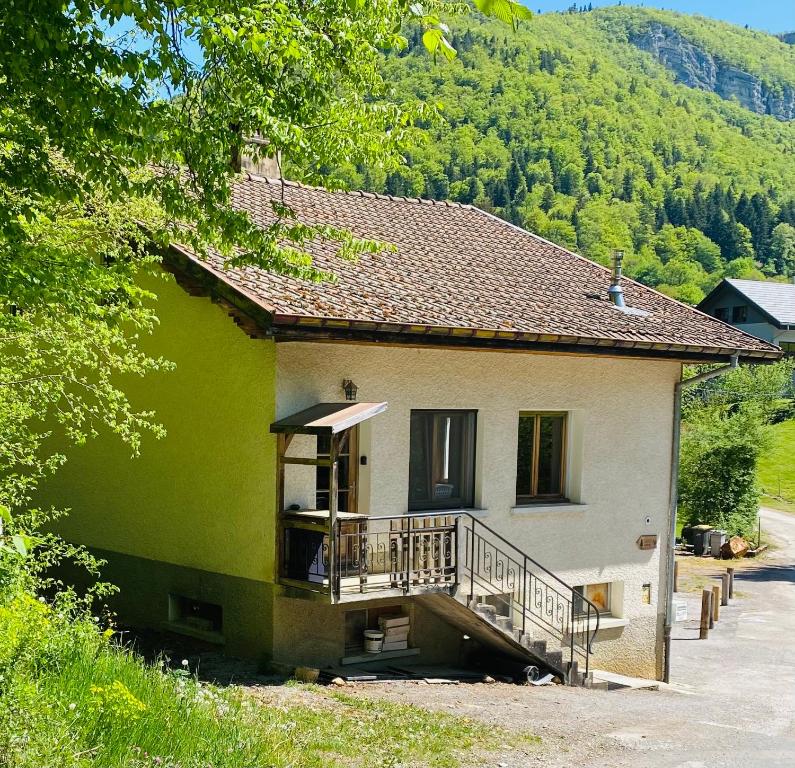 a green and white house with a balcony at Gîte de la forêt in Mont-de-Vougney
