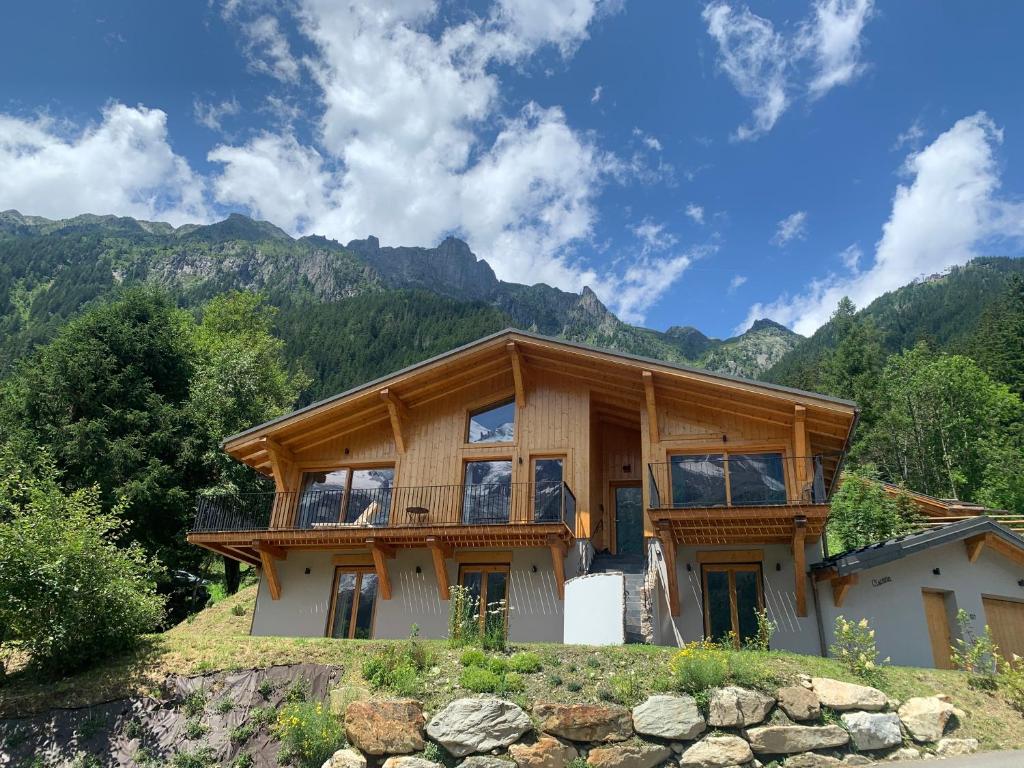 a house on a hill with mountains in the background at Chalet Ciscana Chamonix MontBlanc in Chamonix