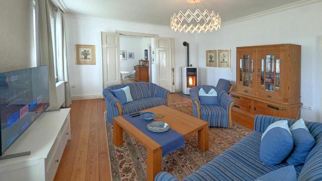 a living room with blue couches and a tv at Haus Thulboden in Heiligenhafen
