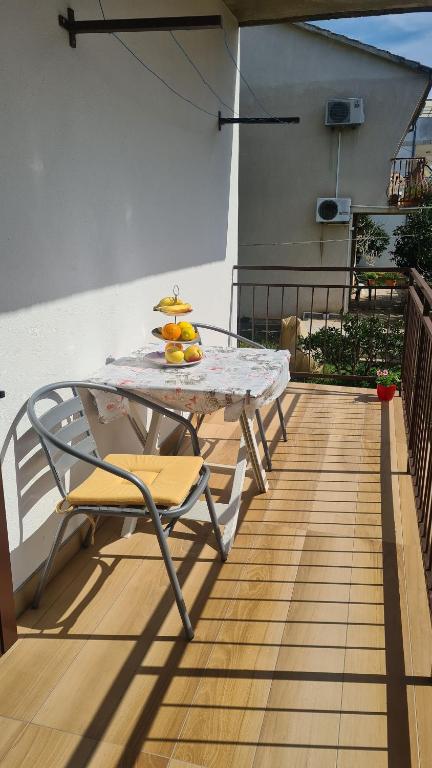 a table on a balcony with a plate of fruit on it at Apartment Antonia in Stari Grad