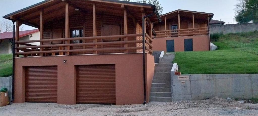 a house with two garage doors in front of it at Drvena Oaza in Gornja Toplica