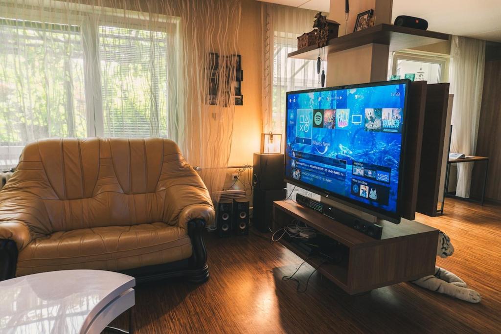 a living room with a couch and a flat screen tv at Dům cestovatele in Uherský Brod