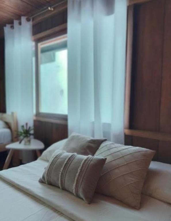 a bed with two pillows on it in a bedroom at The Temple III, Mindo in Mindo