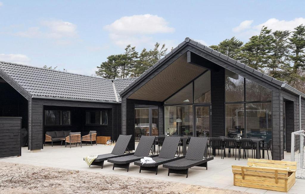 a group of chairs on the patio of a house at Beautiful Home In Ringkøbing With Sauna in Ringkøbing