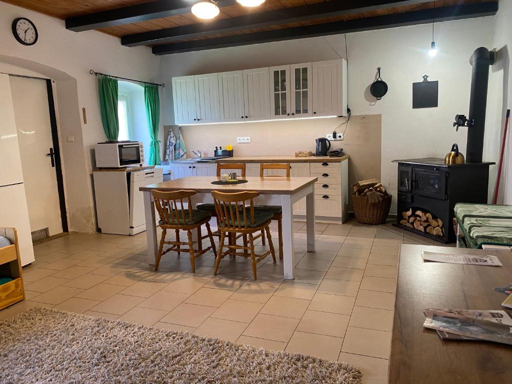 a kitchen with a table and chairs in a room at Stodola v zahradě in Vodňany