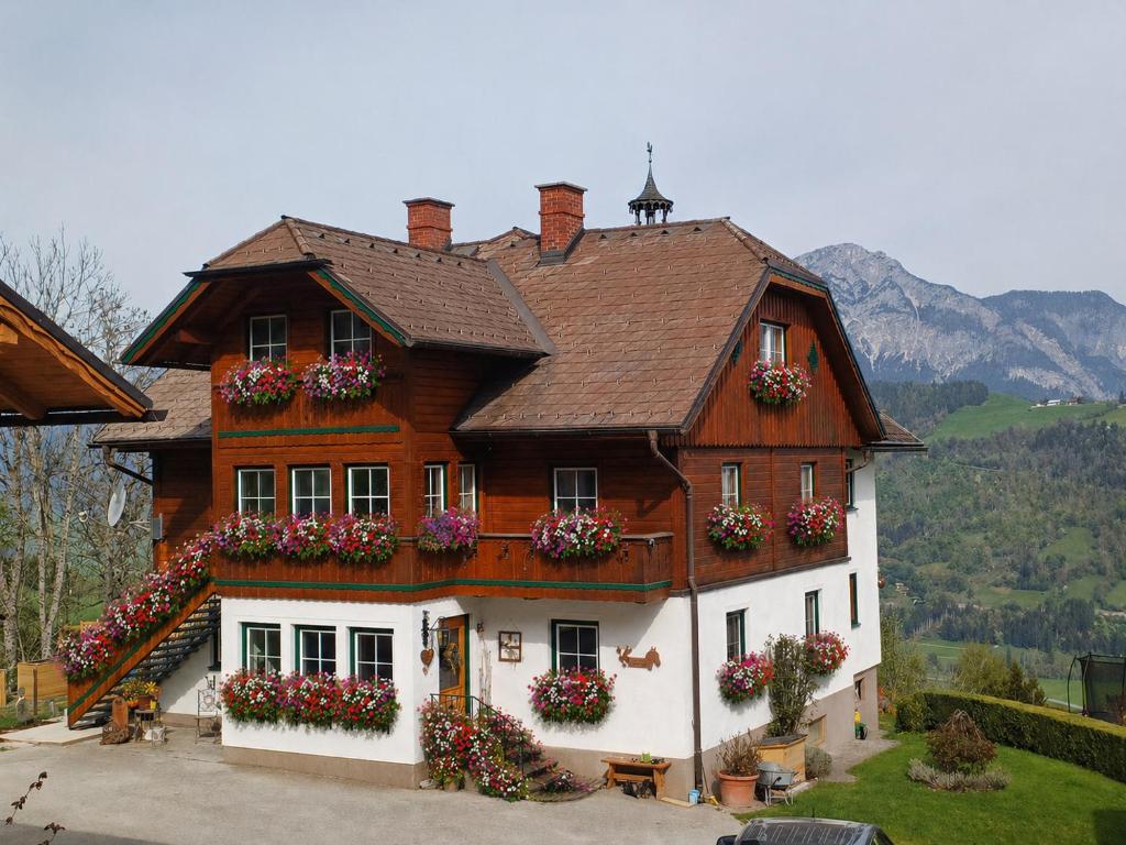 a large wooden house with flowers in the windows at Panoramahof Gupf in Gröbming
